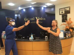 Lisa celebrating with a high five after achieving perfect vision following LaZrPlastique® surgery.
