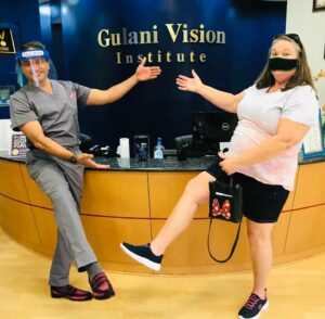 Cataract patient Ginger G. smiling with Dr. Gulani after achieving 20/20 vision at Gulani Vision Institute.