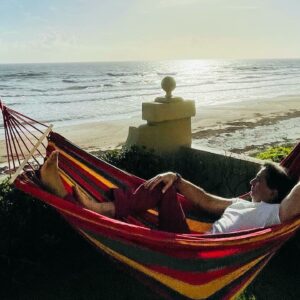 Dr. Arun Gulani relaxing in a hammock by the beach, reflecting on mentorship, growth, and vision beyond limits