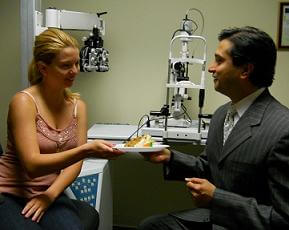 Dr. Gulani Taking Cake From a Patient
