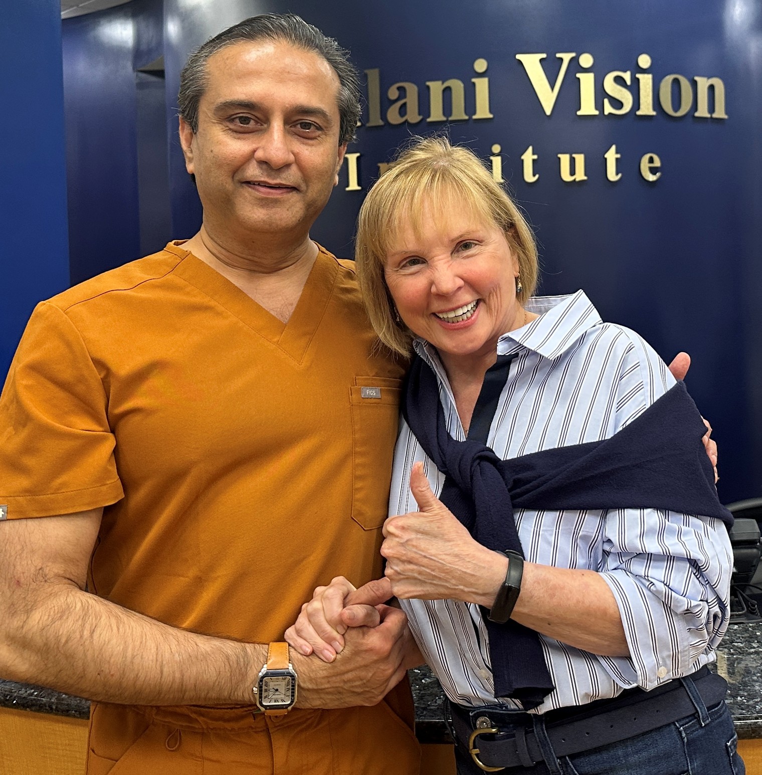 Radial Keratotomy (RK) patient smiling alongside Dr. Arun Gulani at Gulani Vision Institute after customized vision correction and cataract surgery for a complex eye with 32 RK incisions, corneal irregularity, astigmatism, and visual limitations.