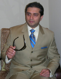 Dr. Gulani Holding Sunglasses