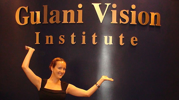 A woman showcasing the sign "Gulani Vision Institute"